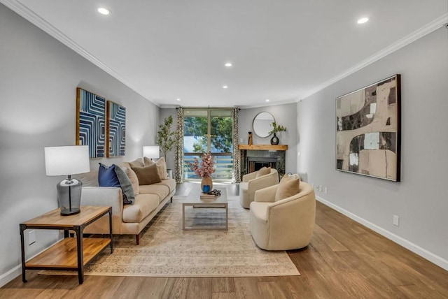 living room featuring hardwood / wood-style flooring, ornamental molding, and a premium fireplace