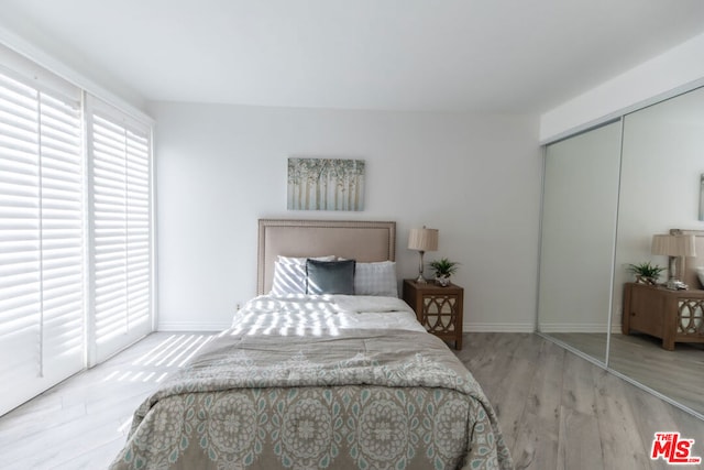 bedroom featuring light wood-type flooring and a closet