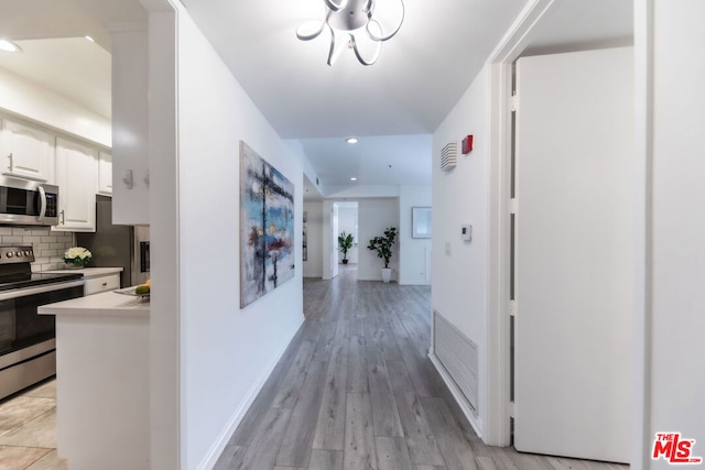 hallway with light hardwood / wood-style floors