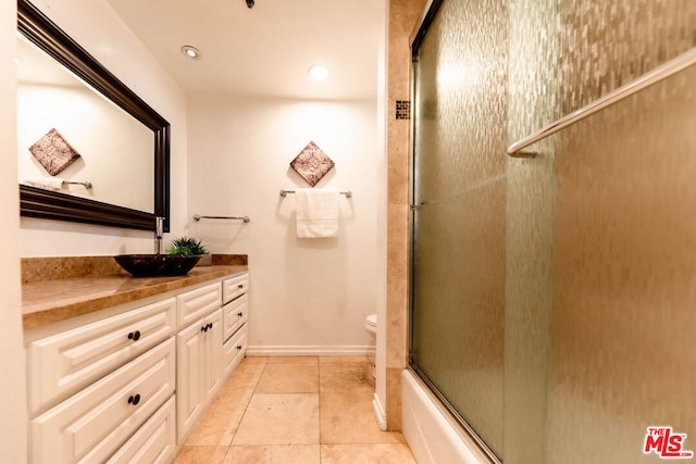 full bathroom with vanity, tile patterned floors, toilet, and combined bath / shower with glass door