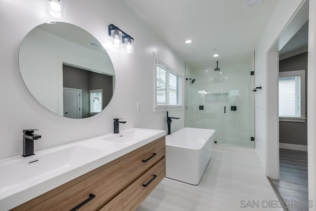 bathroom featuring hardwood / wood-style flooring, plenty of natural light, separate shower and tub, and vanity