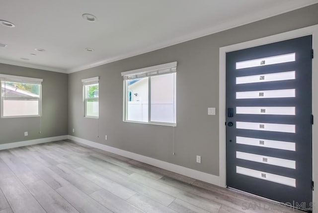 entrance foyer featuring ornamental molding and light wood-type flooring