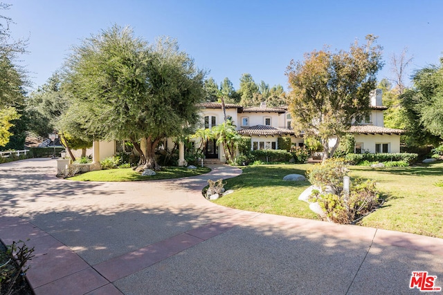 mediterranean / spanish-style house with a front yard