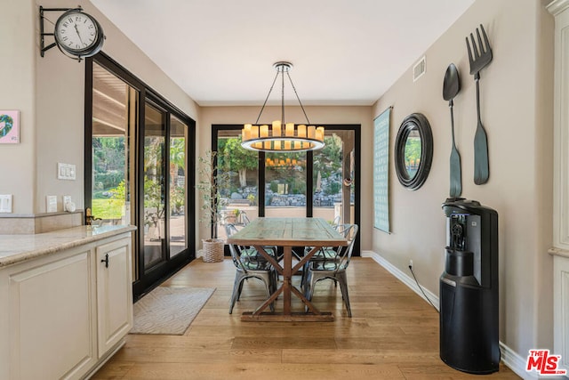 dining area featuring a notable chandelier, light hardwood / wood-style floors, and a wealth of natural light