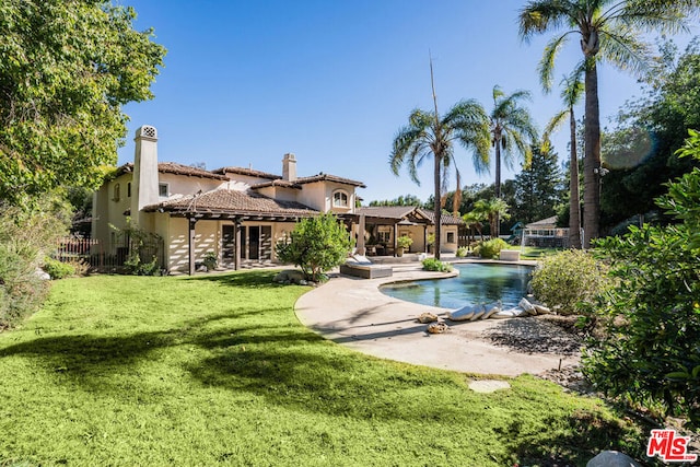 view of pool with a lawn and a patio