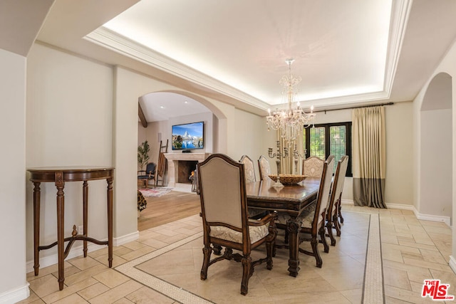 dining space with a raised ceiling and a notable chandelier