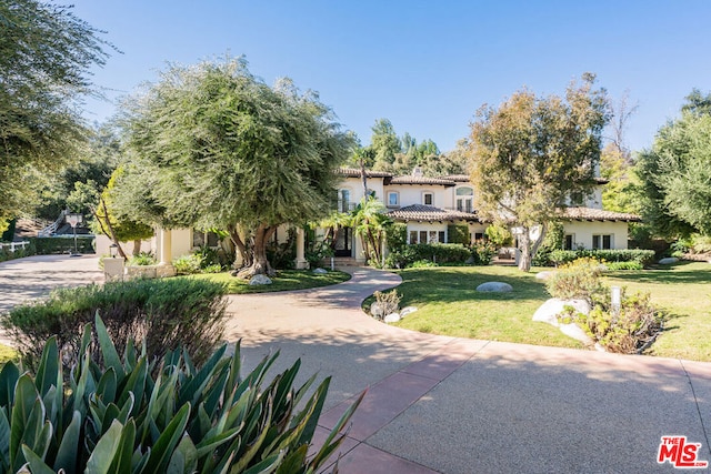 mediterranean / spanish-style home with a front yard