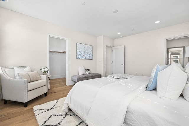 bedroom with a spacious closet, a closet, and light wood-type flooring