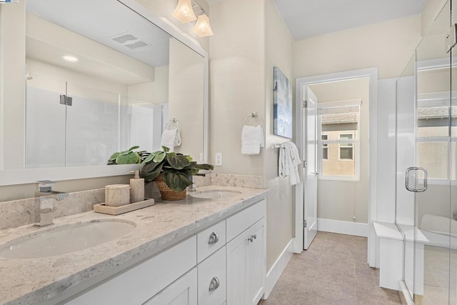 bathroom with an enclosed shower, vanity, and tile patterned floors