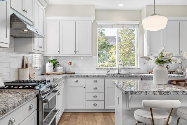 kitchen featuring white cabinetry, light stone countertops, sink, and stainless steel gas range