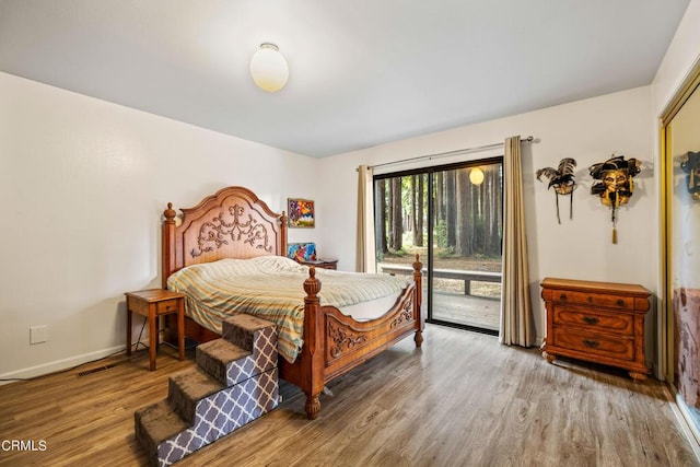 bedroom with wood-type flooring and access to exterior