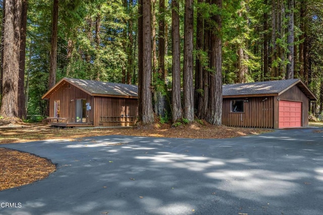 view of front of house featuring a garage and an outbuilding