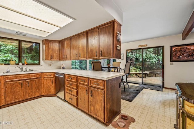 kitchen featuring decorative backsplash, kitchen peninsula, sink, and dishwasher