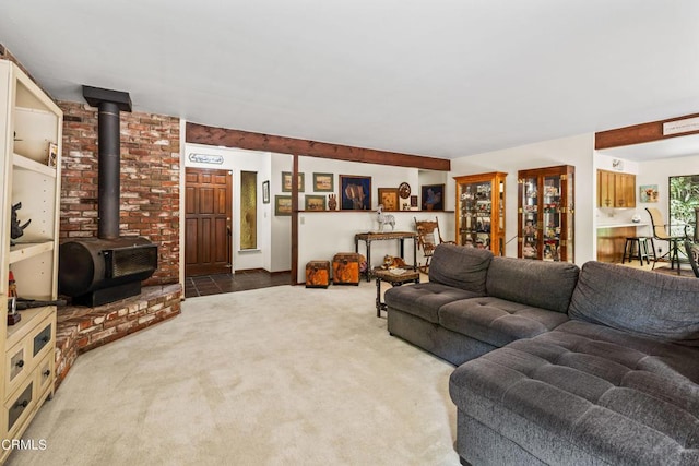 carpeted living room with a wood stove