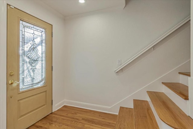 entryway featuring crown molding, a healthy amount of sunlight, and light hardwood / wood-style floors