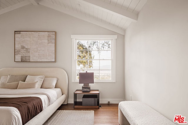 bedroom with wood-type flooring and vaulted ceiling with beams