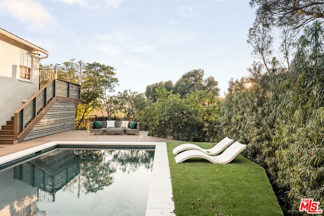 view of swimming pool with an outdoor living space, a yard, and a patio