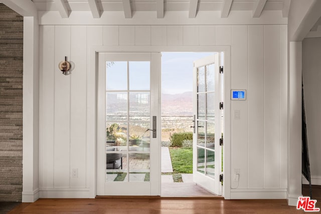 doorway featuring a mountain view, beam ceiling, and hardwood / wood-style flooring