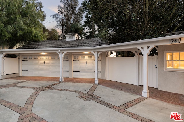 view of garage at dusk