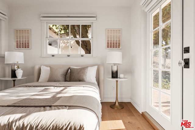 bedroom with access to outside and light wood-type flooring