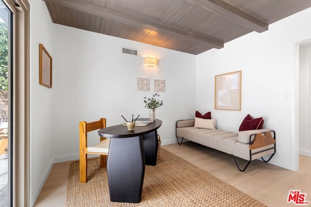 dining area featuring beam ceiling and light hardwood / wood-style floors