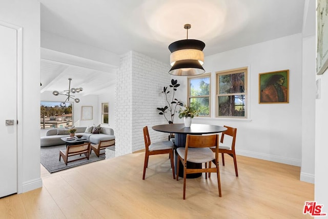 dining room with light hardwood / wood-style floors and beamed ceiling