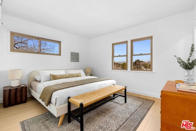 bedroom with multiple windows and hardwood / wood-style floors