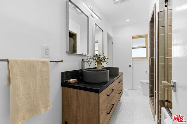 full bathroom featuring tile patterned flooring, vanity, bath / shower combo with glass door, and toilet