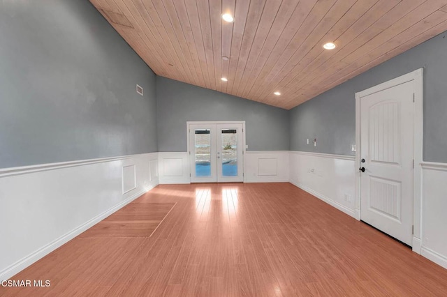 unfurnished room with vaulted ceiling, wooden ceiling, light hardwood / wood-style floors, and french doors