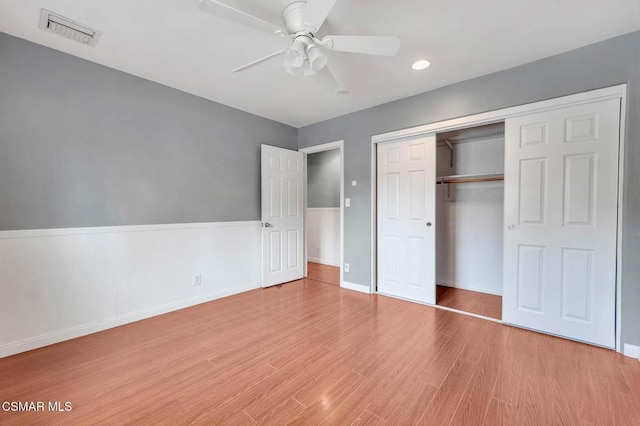 unfurnished bedroom with light hardwood / wood-style floors, ceiling fan, and a closet