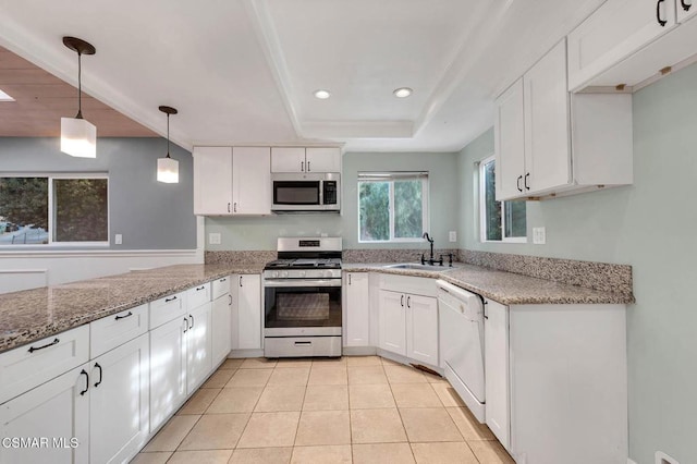 kitchen with sink, hanging light fixtures, stainless steel appliances, white cabinets, and a raised ceiling