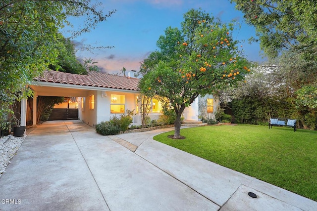 view of front of house featuring a carport and a yard