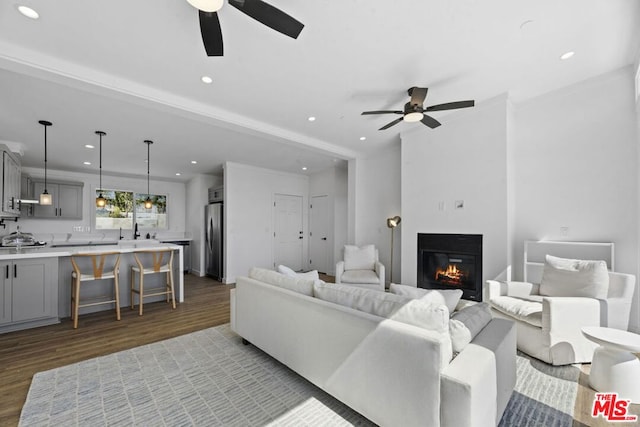 living room with ceiling fan, ornamental molding, and light hardwood / wood-style floors