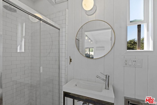 bathroom with sink and a shower with shower door