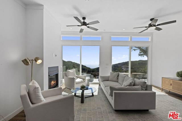 living room featuring crown molding, a mountain view, and ceiling fan