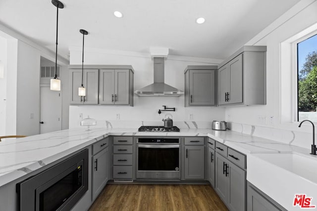 kitchen featuring appliances with stainless steel finishes, wall chimney exhaust hood, sink, and gray cabinetry