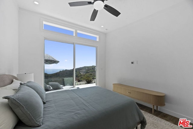 bedroom featuring a mountain view, hardwood / wood-style floors, and ceiling fan