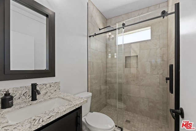 bathroom featuring walk in shower, vanity, and toilet