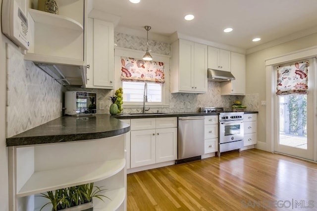 kitchen featuring appliances with stainless steel finishes, light wood-type flooring, hanging light fixtures, and white cabinets