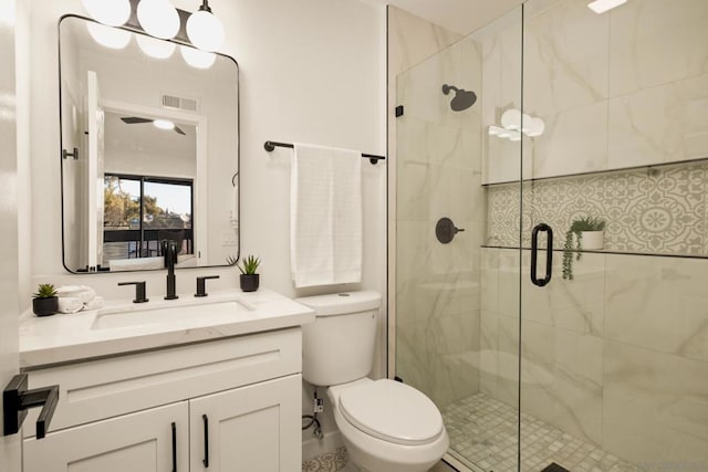 bathroom featuring vanity, an enclosed shower, and toilet