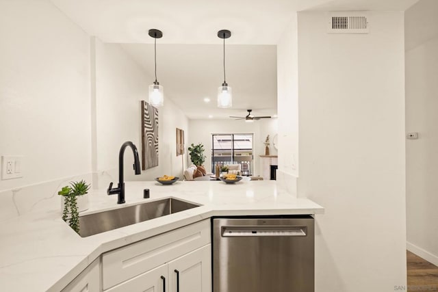 kitchen featuring pendant lighting, sink, white cabinetry, light stone counters, and stainless steel dishwasher