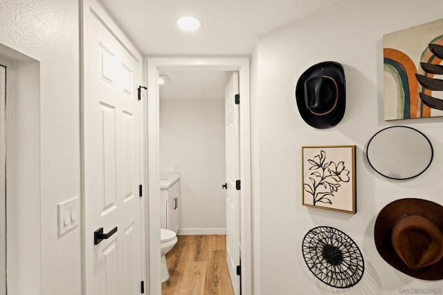 bathroom featuring wood-type flooring, toilet, and vanity