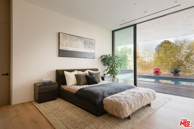 bedroom featuring light hardwood / wood-style flooring, access to outside, and expansive windows