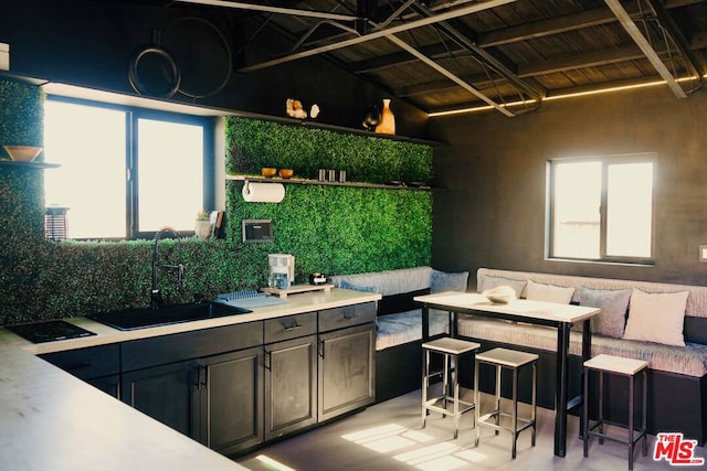 kitchen featuring breakfast area, sink, wood ceiling, and beamed ceiling