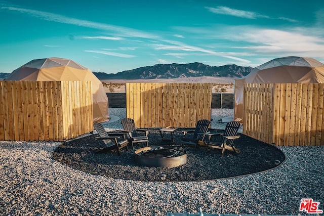 view of yard featuring a mountain view and an outdoor fire pit