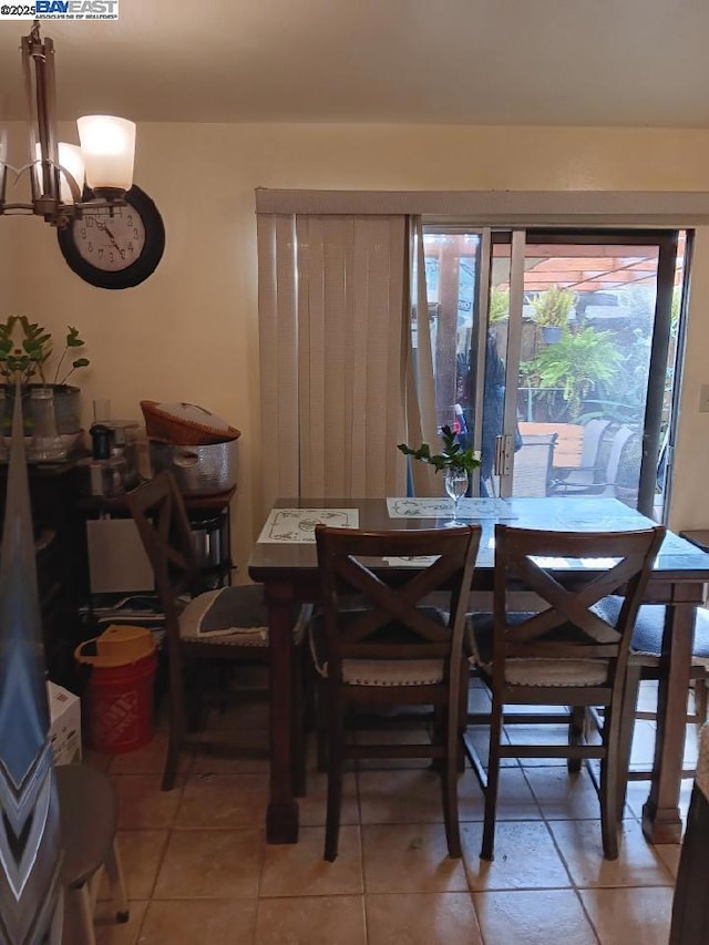 tiled dining area featuring a chandelier