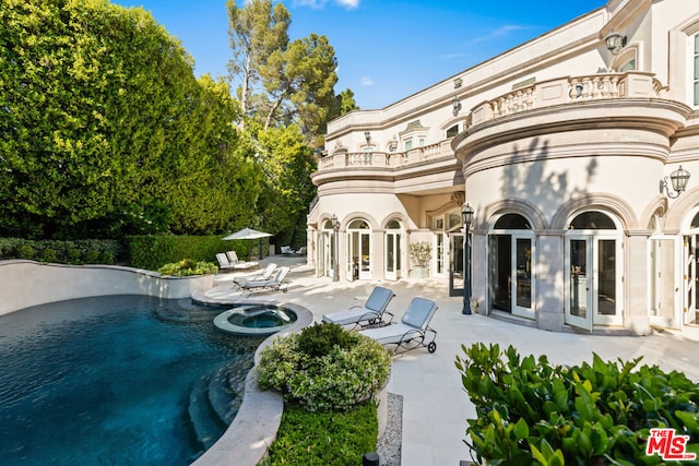 exterior space with an in ground hot tub and a patio area