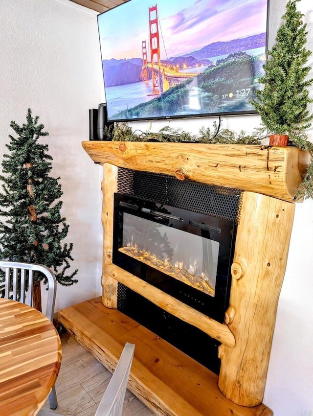 details with wood finished floors and a glass covered fireplace