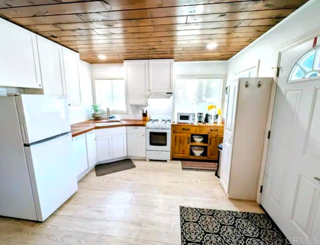 kitchen featuring white appliances, white cabinetry, wooden ceiling, and a sink