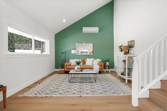 living room featuring vaulted ceiling, an AC wall unit, and wood-type flooring